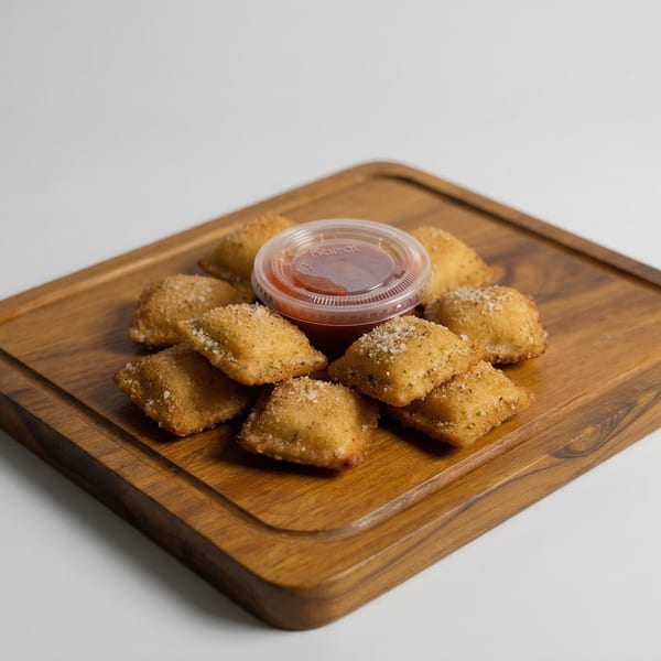 Golden-brown fried ravioli, sprinkled with salt and herbs, arranged around a small cup of marinara sauce on a wooden board.